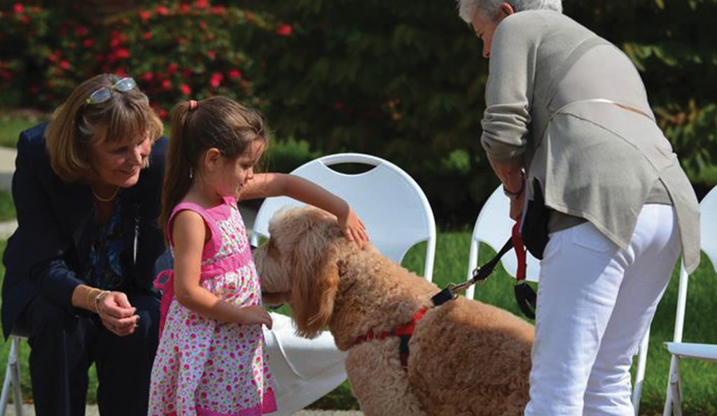 Child Petting a Dog at Westminster Canterbury Richmond in Richmond, VA